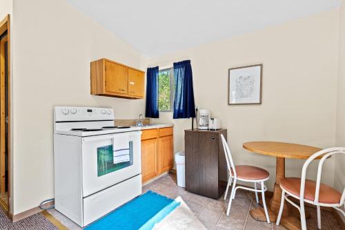 a kitchen with a white stove top oven next to a table at Harney Camp Cabins in Hill City