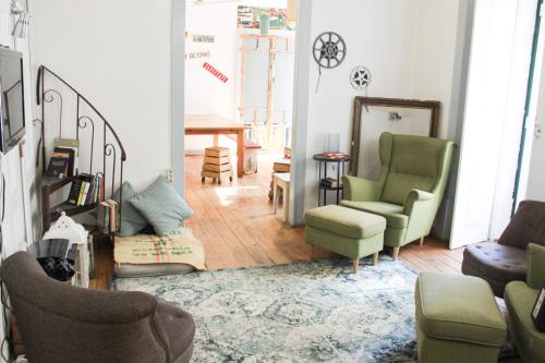 a living room with two chairs and a table at Alface Hall Hostel & Bar in Lisbon