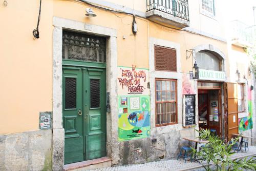 una puerta verde al lado de un edificio en Alface Hall Hostel & Bar, en Lisboa