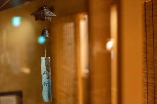 un paraguas colgando de una pared en una habitación en 京町屋の宿 天神庵, en Kioto