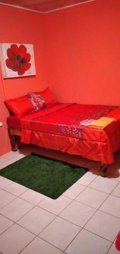 a red bedroom with a bed with red sheets and green mats at Mack's Home in Clifton