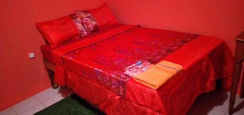 a red bed with red sheets and pillows at Mack's Home in Clifton