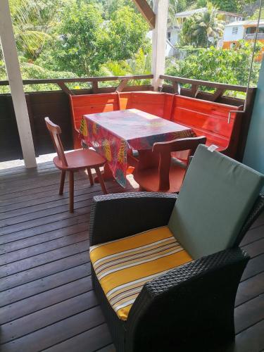 a patio with a table and chairs on a deck at les gîtes de la belle fleur laurier rose in Le Gosier