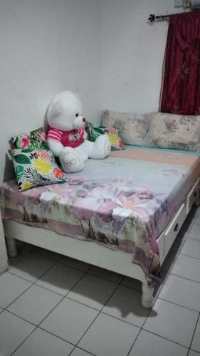 a stuffed teddy bear sitting on a bed at Mack's Home in Clifton