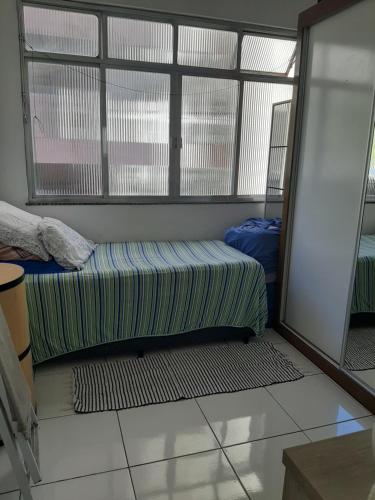 a room with a bed in a room with windows at Aconchego da Lapa in Rio de Janeiro