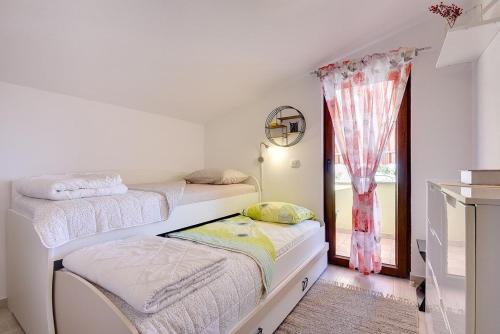 a bedroom with two beds and a window at Casa Sandi in Pula