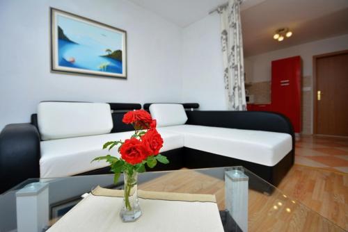 sala de estar con sofá y mesa con rosas rojas en Apartment with sea view 3558-3 en Žuljana