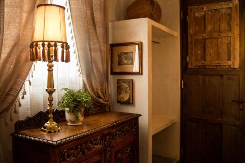 a lamp on a dresser in a room with a window at Casa Olivia in Mérida