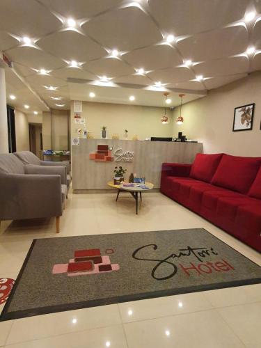 a living room with a red couch and a rug at HOTEL SANTORI in Pasto