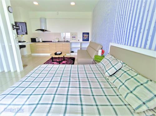 a living room with a bed and a kitchen at Comfort Zone Premium Guesthouse @ Evo Bangi in Bangi