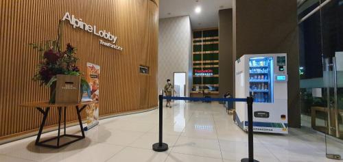 a woman walking through a shopping mall with an atm machine at TreeParkCity apartments by WinsHome in Tangerang