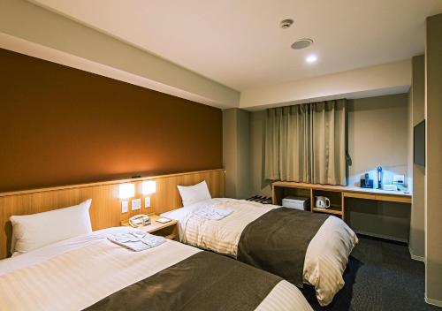 a hotel room with two beds and a window at Grand Hotel Fujika in Nayoro