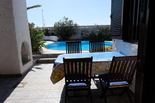 ポリス・デ・アボナにあるNice little house with pool, seaview big sunterrace for 4 pers.のテーブルと椅子、テーブル、プール付