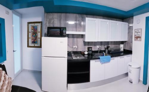 een keuken met witte kasten en een koelkast bij MH House APT #1 in Carolina
