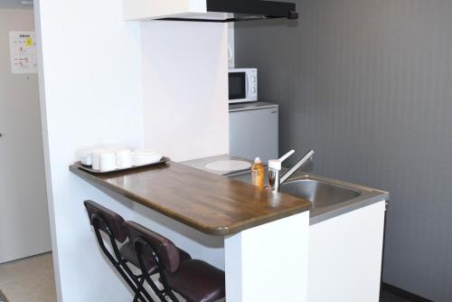 a small kitchen with a sink and a microwave at Hotel Urbansea 2 Matsuo in Naha