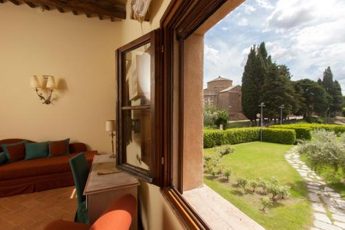 a living room with a window looking out at a garden at Sovana Hotel & Resort in Sovana