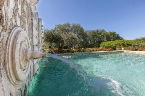 a water fountain pouring into a swimming pool at Sovana Hotel & Resort in Sovana