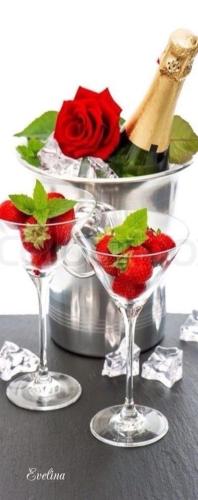 two wine glasses with strawberries and a bottle of champagne at Ocean Breeze Executive Bed and Breakfast in North Vancouver