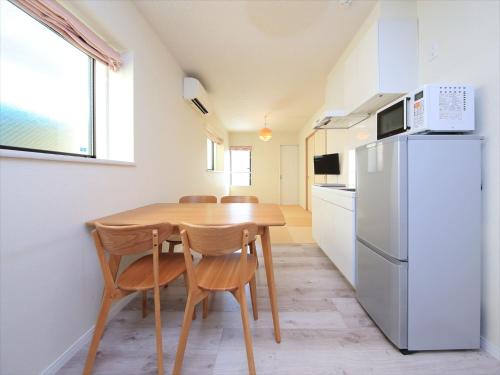 a kitchen with a wooden table and a refrigerator at COTO Tokyo Shibuya 2 in Tokyo