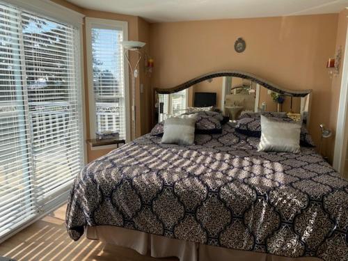 a bedroom with a large bed and a large window at Ocean Breeze Executive Bed and Breakfast in North Vancouver