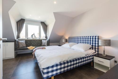 ein Schlafzimmer mit einem großen Bett und einem Sofa in der Unterkunft Haus Therese mit Sauna in Zingst
