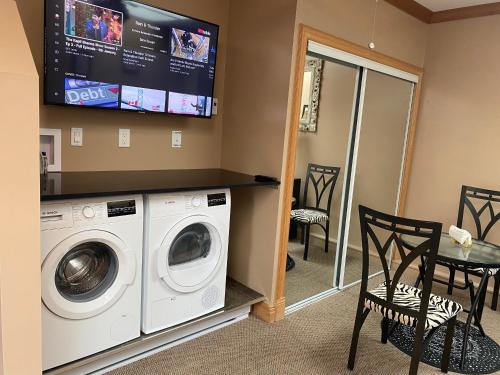 a laundry room with a washing machine and a tv at Ocean Breeze Executive Bed and Breakfast in North Vancouver