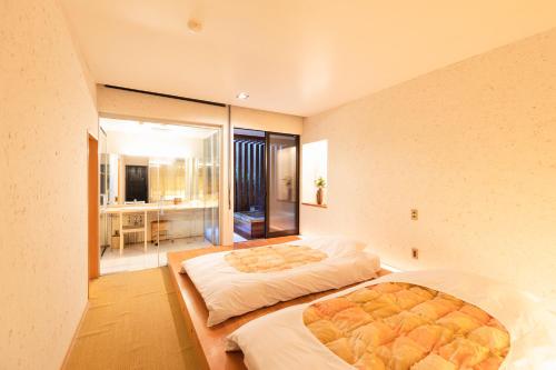 two beds in a room with a large window at Yushintei in Hakone