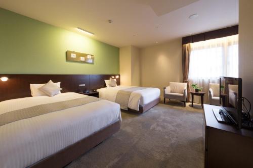a hotel room with two beds and a television at Hotel Tenjin Place in Fukuoka