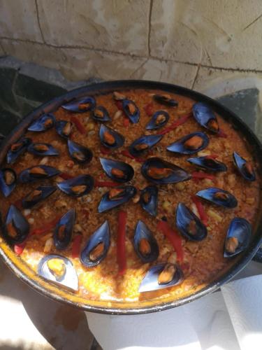 a pizza with mussels on it in a pan at Los Duendes in El Puerto de Santa María