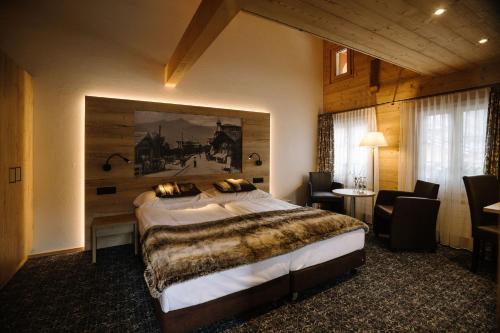 um quarto com uma cama e um quadro na parede em Hotel PINTE em Grindelwald