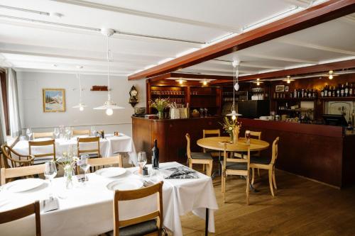 a restaurant with tables and chairs and a bar at Hotel PINTE in Grindelwald