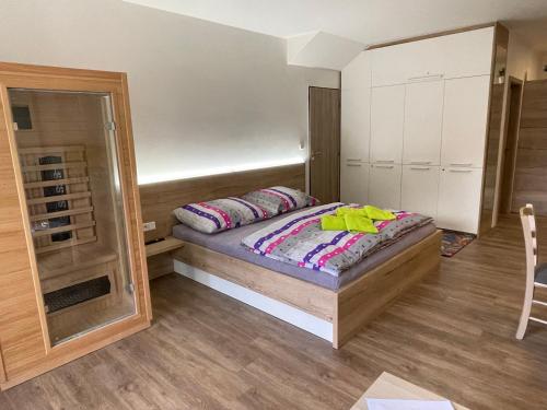 a small bedroom with a bed and a mirror at Apartment WELLNESS Vlčková in Vlčková