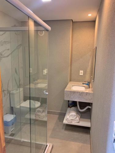 a bathroom with a glass shower and a toilet at Resort Île de Pipa Flat in Pipa
