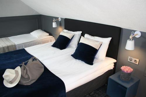 a bedroom with two beds with black and white pillows at Sadama street Villa in Pärnu