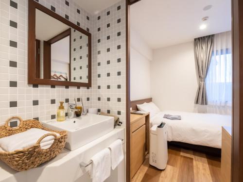 ein Bad mit einem Waschbecken, einem Spiegel und einem Bett in der Unterkunft ACCESS by LOISIR HOTEL Nagoya in Nagoya