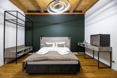 a bedroom with a large bed and a television at Oysters & Bubbles Gastro Hotel. Rynok square in Lviv