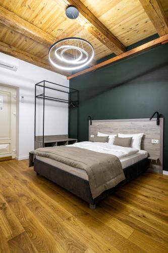 a bedroom with a large bed and a green wall at Oysters & Bubbles Gastro Hotel. Rynok square in Lviv