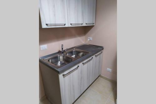 a kitchen with a sink and white cabinets at CASAL MERCURI SALENTO in Alezio