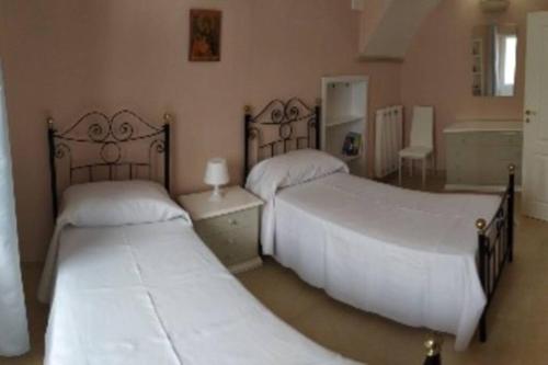 a bedroom with two beds and a table at CASAL MERCURI SALENTO in Alezio