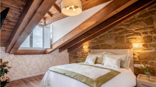 a bedroom with a bed and a stone wall at Apartamentos Turísticos de La Vega in Haro