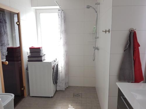 a white bathroom with a shower and a sink at Riverstar in Pärnu