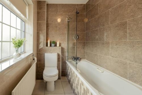 a bathroom with a toilet and a bath tub at Seaview Heights in Dingle