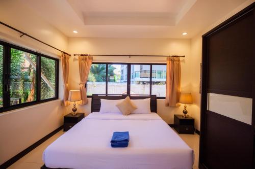 Un dormitorio con una gran cama blanca con dos lámparas. en Luxury Pool Villa 4 BR 900M beach 1.5 KM downtown, en Pattaya South