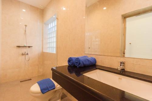 Un baño con lavabo, inodoro y espejo. en Luxury Pool Villa 4 BR 900M beach 1.5 KM downtown, en Pattaya South