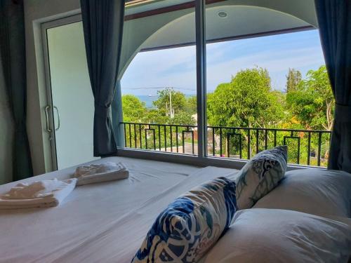 a room with a bed with a large window at Seattle Samaesarn Resort in Ban Samae San