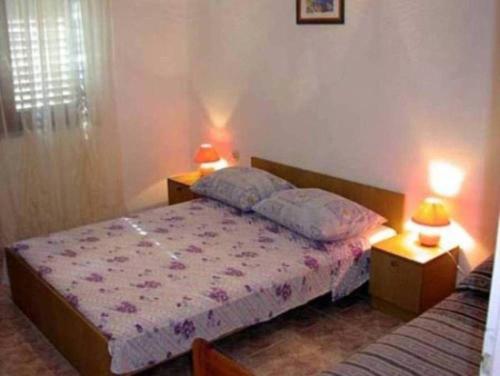 a bedroom with a bed and two tables and two lamps at Apartment in Kali with sea view, balcony, air conditioning, WiFi (4230-2) in Kali