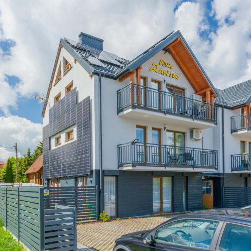 a large white building with a balcony at APARTAMENTY PIAMOLA Willa Zacisze Kąty Rybackie in Kąty Rybackie