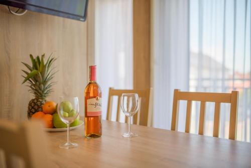 a bottle of wine sitting on a table with two glasses at APARTAMENTY PIAMOLA Willa Zacisze Kąty Rybackie in Kąty Rybackie