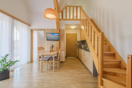 a kitchen and dining room with a table and stairs at APARTAMENTY PIAMOLA Willa Zacisze Kąty Rybackie in Kąty Rybackie