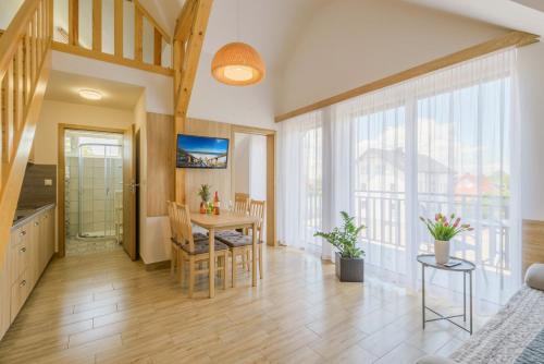 a kitchen and dining room with a table and chairs at APARTAMENTY PIAMOLA Willa Zacisze Kąty Rybackie in Kąty Rybackie